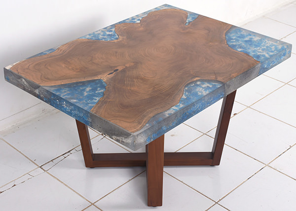 teak and resin coffee table with crossed wooden legs