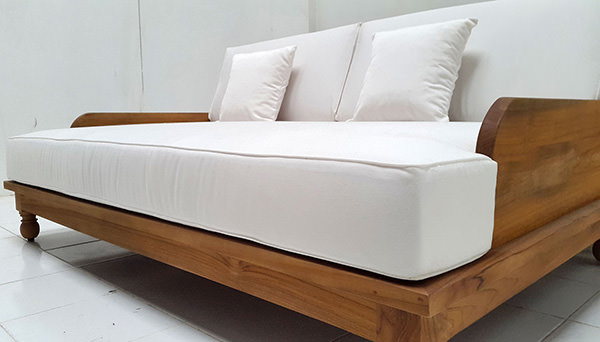 grade A teak garden daybed with natural finish with weatherproof white garden mattress and throwing pillows