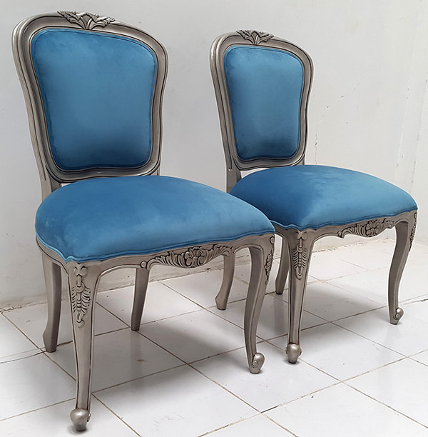 two carved dining chairs with blue upholstery