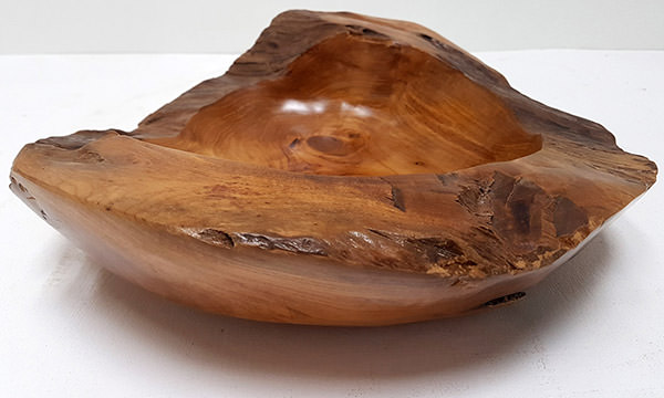 teak plate with a natural shape and a glossy finish