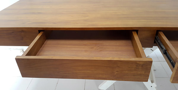 teak desk with wall hanging and two drawers