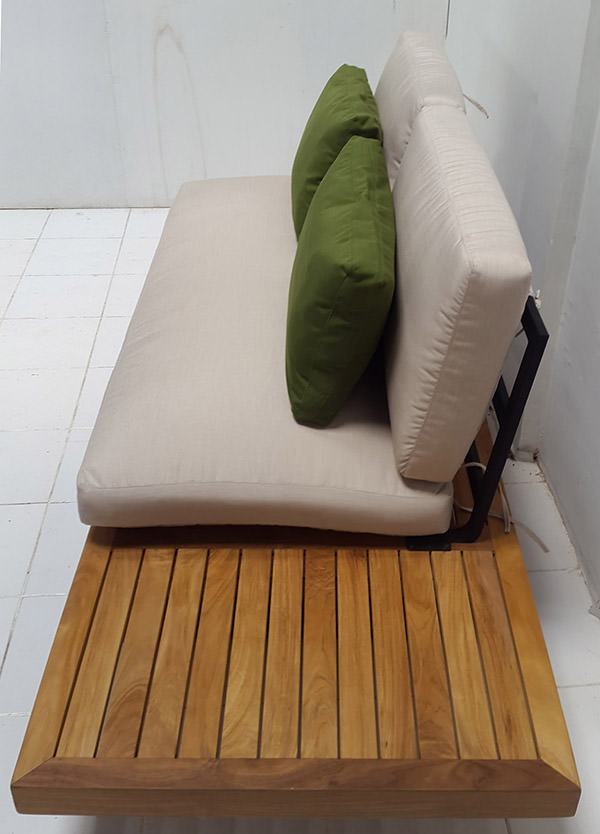 outdoor teak sofa with two green cushions