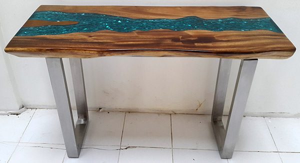 suar table with stainless steel legs and blue resin on the table top