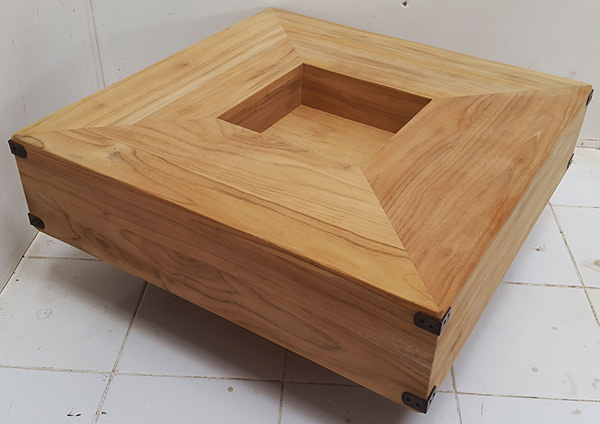square teak coffee table with a square hole and a natural finish