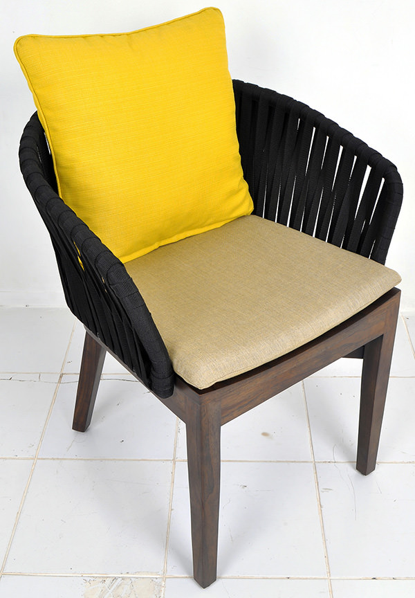 curved outdoor chair with teak seat and black ropes backseat and linen seat cushion