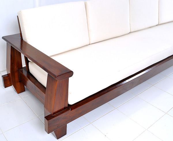 indoor dark brown wooden couch with white cushions