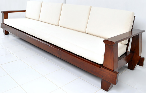 dark brown wooden couch with white cushions