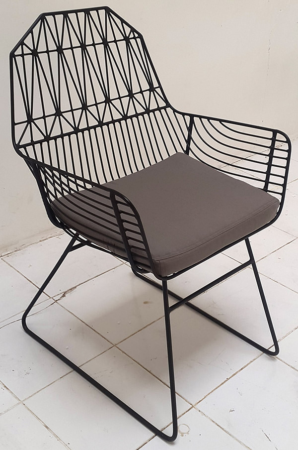outdoor iron armchair with welded geometric pattern and cushion with grey linen